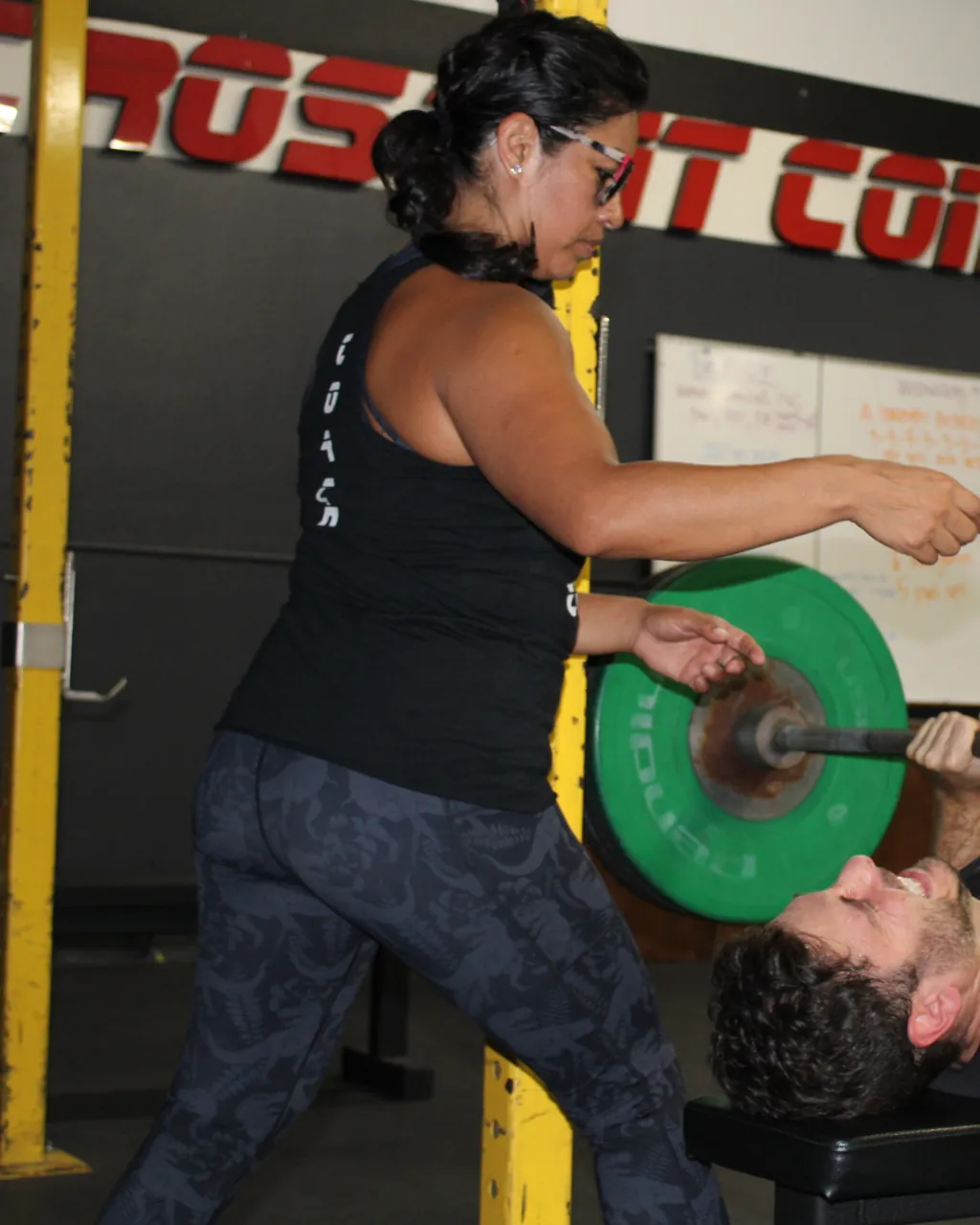 Coach Rosie spotting a member on the bench press